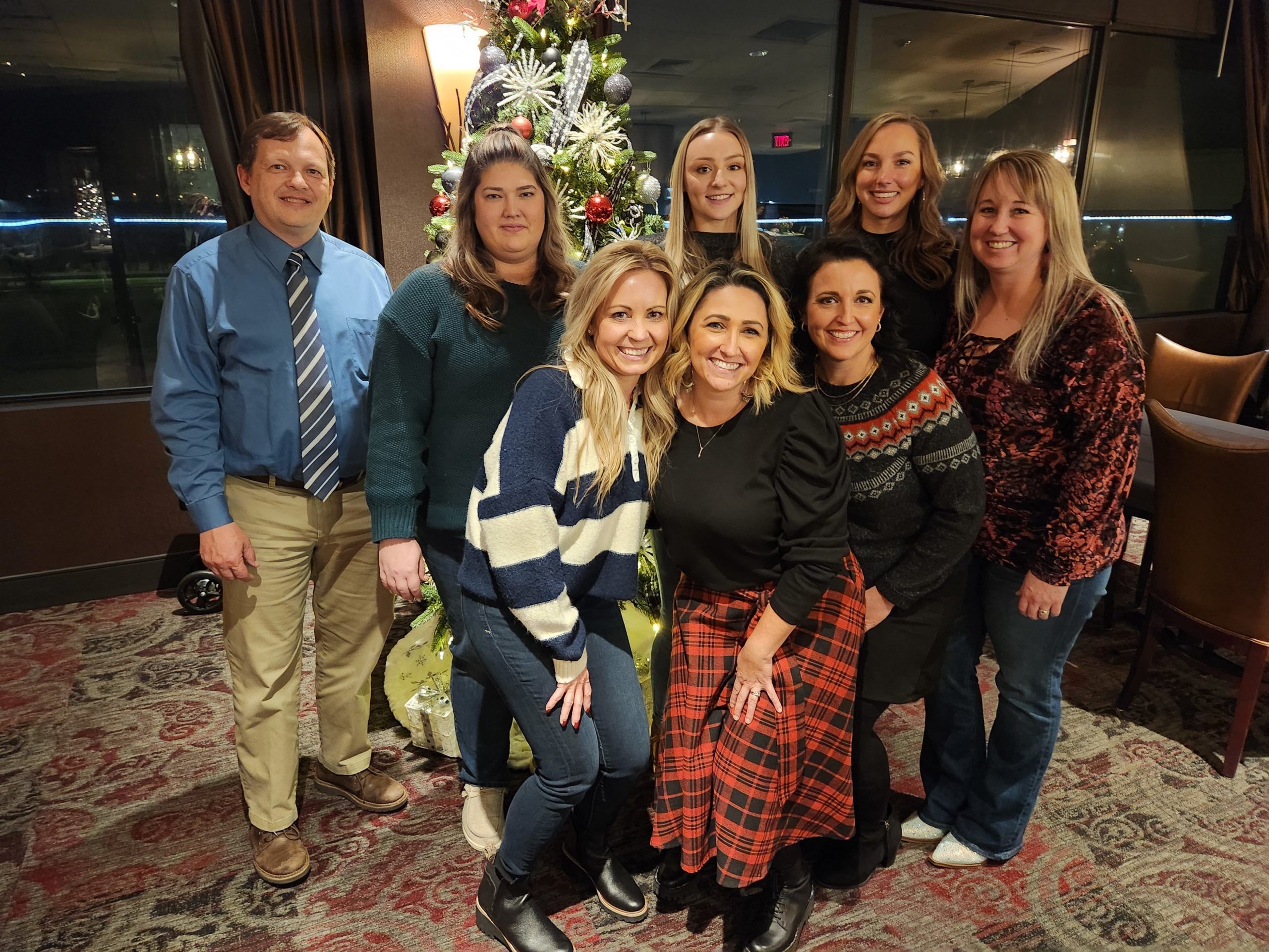 img-responsive homeimg The entire dental team of Fourth Street Family Dental posing together in front of a Christmas tree in a high rise building in Hermiston, OR